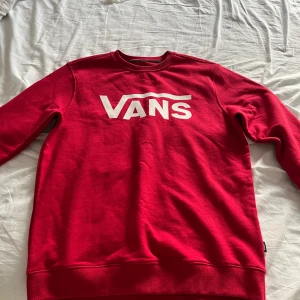 Röd sweatshirt från Vans - Säljer en snygg röd sweatshirt från Vans i storlek S. Den har en klassisk design med det ikoniska Vans-loggan i vitt på bröstet. Perfekt för en avslappnad stil och passar bra till både jeans och shorts. Tröjan är i mycket bra skick.