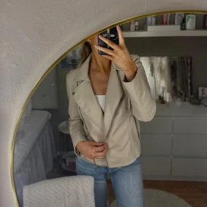 Beige skinnjacka från Only - Säljer en snygg beige skinnjacka från Only. Jackan har en cool bikerstil med dragkedja och långa ärmar. Perfekt för höst och vår, och den är i mycket bra skick. Passar perfekt till jeans för en avslappnad look.🧸🦢🪐