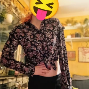 Vintage blus av yessica - Säljer en vintage blus av märket Jessica med blommigt mönster. Blusen har långa ärmar med en volang detalj högst upp på ärmen. Perfekt för både vardag och fest! 🌸