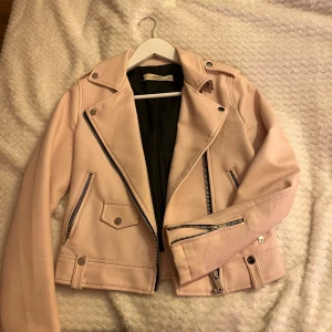 Rosa skinnjacka - Säljer en snygg rosa skinnjacka med coola dragkedjedetaljer. Finns skada i ena armhålet (kika på bild 3). Den är i bra skick