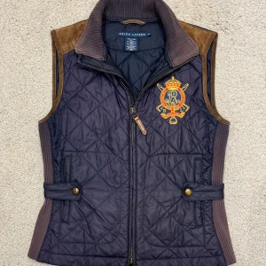 Mörkblå Quiltad Väst från Ralph Lauren - Märke: Ralph Lauren Storlek: XS Färg: Mörkblå med bruna detaljer Skick: Mycket bra skick