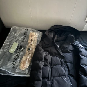 Canada goose Wyndham  - Perfekt skick då den är ny och använd en gång, den är varm och bra för vintern. Den är inte äkta men väldigt bra kvalitet, den är en storlek M men den passar även S om du vill ha en hel video på den är de bara fråga.😊