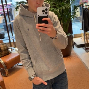 Ralph Lauren hoodie grå - Säljer denna efterfrågade ljusgrå Ralph Lauren hoodie. Riktigt populär hoodie som är stilren. Skön passform.  Skick: 9/10 Inga som helst tecken på användning. Nypris: ca 2199kr, mitt pris 749kr Tveka inte på att höra av dig vid eventuella frågor.