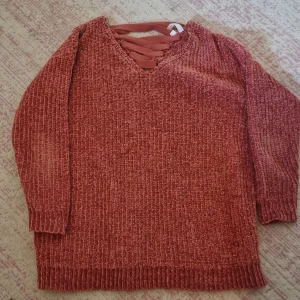 Rostfärgad stickad tröja från Rainbow - Mysig rostfärgad stickad tröja från Rainbow i storlek M. Tröjan har en snygg snörning vid halsen och långa ärmar. Perfekt för höst och vinter för en avslappnad och stilren look.