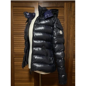  dunjacka Moncler (bady) - Säljer min snygga och varma marinblåa dunjacka från Moncler. Jackan har en glansig och är perfekt för kalla vinterdagar. Den har en huva och dragkedja framtill. Storlek 2 som motsvarar M 