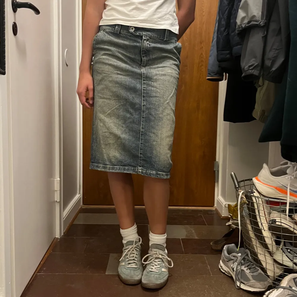 Säljer en riktigt snygg jeanskjol i blå denim. Kjolen har en medellång längd och en bekväm passform med knapp och dragkedja fram. Den har en liten slits bak som ger extra rörlighet men går att sy ihop, däremot har den en nit som sitter (bild 3). Den kan man ta bort om man vill eller om man vill lägga till en knapp själv. Passar S/M med en lågmidjad/mellanmidjad passform.. Kjolar.