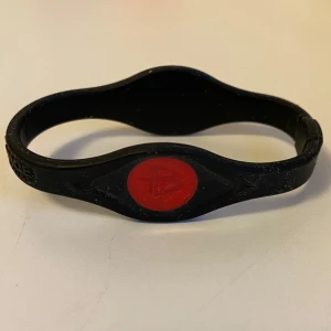 Power Balance-armband - Power Balance-armband. Aldrig använt.   Power Balance- armbandet har två hologram, en på vardera sidan av armbandet. Hologrammen är designade för att "resonera med och svara på kroppens naturliga energifält". Detta påstås förbättra flexibilitet, balans och styrka. 