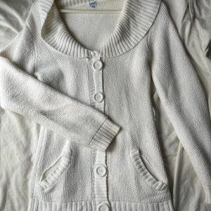 Vit stickad kofta med stora knappar - Mysig vit stickad kofta med stora knappar framtill och två fickor. Mycket fint skick!! Storlek S💕💕