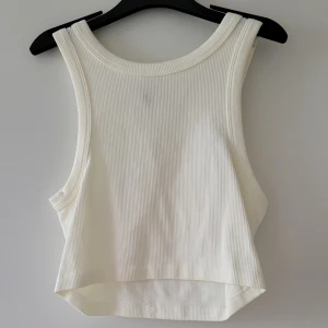 Vit ribbad linnetopp  - Säljer en basic vit ribbad linnetopp från Divided HM. Den är ärmlös och har en croppad passform, och är oanvänd. Storlek: S  Skickas inslagen i silkespapper i vattentätt paket.   Skicka pm för fler bilder. 