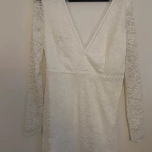 Vit spetsklänning med v-ringning - Säljer en superfin vit spetsklänning med v-ringning. Den har långa ärmar och en tight passform som verkligen framhäver figuren. Perfekt för fest eller andra speciella tillfällen så som student eller avslutning🩶🤍endast använt den en gång