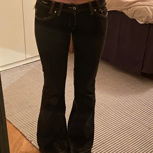 Svarta bootcut jeans - Säljer ett par svarta bootcut jeans  i bra skick. De är lågmidjade och har en snygg passform som sitter tight upptill och blir vidare nedtill. Perfekta för både vardag och fest! Är väldigt långa (jag är 180)