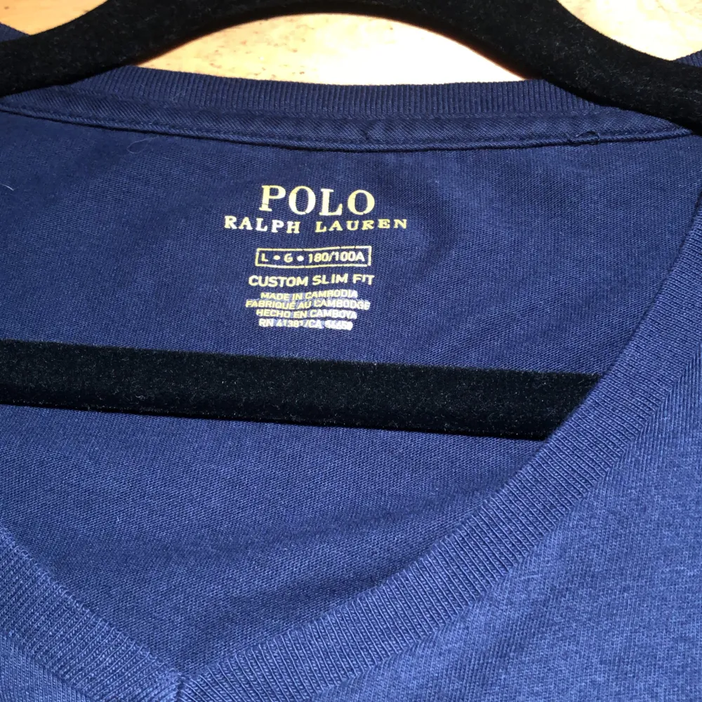 Ralph Lauren mörkblå t-shirt i mjuk bomull med V-ringad. Klassisk passform och stilren design. Perfekt för både vardag och avslappnade tillfällen – ett tidlöst basplagg.Den har också inga hål eller fläckar. Jag kan diskutera priset.. T-paidat.