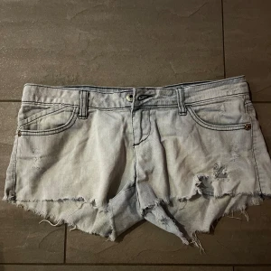 Lågmidjade jeansshorts - Säljer ett par ljusa jeansshorts i mycket bra skick. De har en cool, sliten look med fransiga kanter. Perfekta för sommaren! De är lågmidjade och har ett mycket bra skick🩷Passar perfekt till en avslappnad stil.🫶🏼🥰 midjemåttet tvärs över är 43cm🥰
