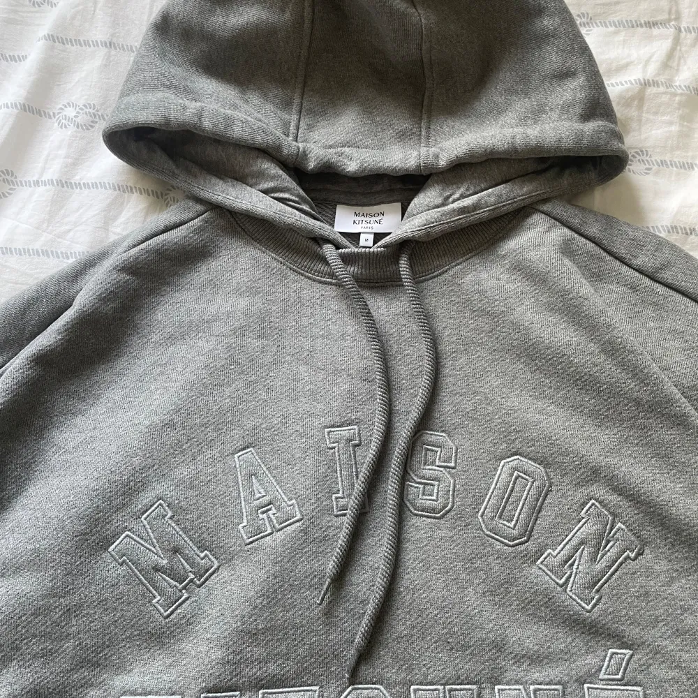 Säljer en snygg grå hoodie från Maison Kitsuné. Den är i storlek M och gjord av 100% bomull, vilket gör den superbekväm och perfekt för vardagen. Passar om du är runt 183-190 beror på hur mycket du väger. Skriv över minsta lilla fundering!!. Tröjor & Koftor.