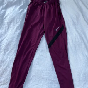 Nike track pants - Vinröda Nike track pants storlek S. Litet brännhål men syns knappt. Skriv gärna om du har några frågor!👍