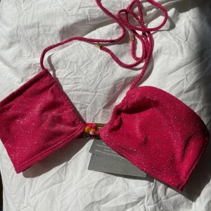 Rosa glitter bikini - Oanvänd bikini med lapparna Ivar  toppen storlek M som är justerbar vid brösten och ryggen. Och trosorna storlek S