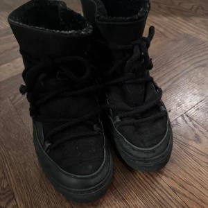 Inuikii - Klassiska svarta Inuikiis i stl.37. Vänstra skon behöver lagas lite längst fram där sömmen gått upp. Se bild.