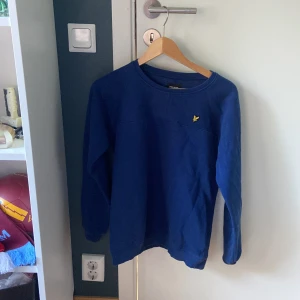 Lyle & scott junior tröja  - Säljer nu en blå lyle & scott tröja i storlek 14/15 y men passar S. Använd ett fåtal gånger och är i superskick. Köpt i london