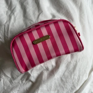 Victorias secret necessär  - Rosa randig liten necessär från Victorias secret 💖 Lite sliten på loggan på framsidan annars fräsch 🪩