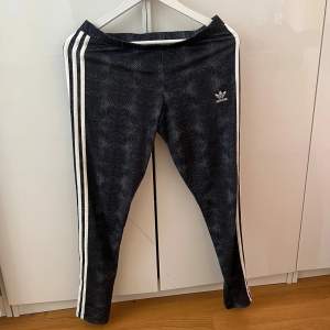 Adidas leggings i storlek 42 med ormskinns mönster. Helt oanvända.  Färg: grå/svart/vitt