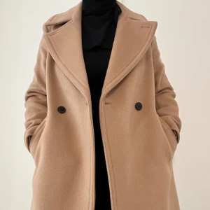 Beige ullkappa från Club Monaco - strl M (NY) - Säljer en helt ny och oanvänd beige ullkappa från Club Monaco i storlek M men passar även S för en mer oversize passform. Kappan är i högkvalitativ ull och har kvar alla originalprislappar. Perfekt för höst- och vintergarderoben, då den både är elega