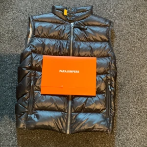  Parajumper väst - Säljer en snygg svart dunväst från Parajumpers. Västen är quiltad och har en dragkedja framtill. Perfekt för höst och vår när du vill hålla dig varm men ändå se stilren ut. Den har en liten reva på insidan, men annars i bra skick. Kommer med originalförpackning.