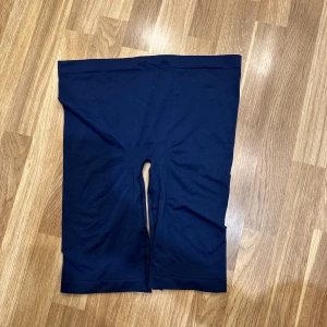 Svarta cykelshorts - Marinblåa cykelshorts i stretchigt material. Perfekta för träning eller en avslappnad dag. De har en enkel design utan mönster eller detaljer. Oanvänd! Vet ej storleken men materialet töja ut ganska mycket. Skulle säga M/L storlek :) 