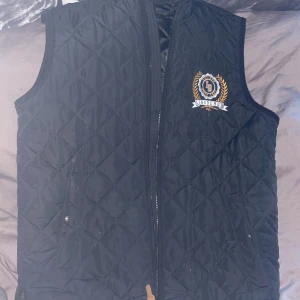 Svart quiltad väst från Lindbergh - Säljer en snygg svart quiltad väst från Lindbergh. Västen är perfekt för höst och vår, och har en praktisk dragkedja framtill. Den är i riktigt bra skick och redo för nya äventyr. Köpte den för ungefär 599