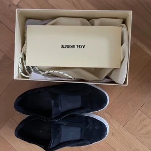 Axel Arigato skor 39 - Tja, säljer dessa cleana arigatos i strl 39 (sitter som 40/40,5). Skulle säga hyfsat skick 7/10. Är sönder på hälen som syns i bild 4, men inte in i själva skon och påverkar inte känslan när dom är på, bara att fråga om det är nåt!  mvh