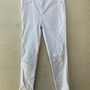 Vita jeans från 157 - Säljer ett par vita jeans från märket 157. De har en klassisk femficksdesign och är i en snygg vit färg som passar perfekt till alla tillfällen. Jeansen har en knapp med märkets logga och ser ut att vara i bra skick. Perfekta för både vardag och fest!