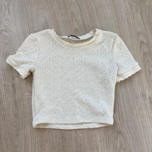 Virkad kortärmad topp  - En jättefin fin cremevit virkad kortärmad topp från zara som inte säljs längre. Den är använd fåtal gånger och är i ett mycket bra skick. Säljer den för att den är för liten.