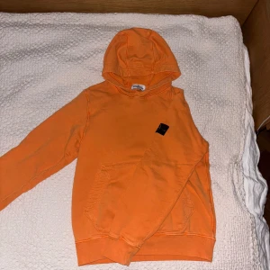 STONE ISLAND HOODIE - Säljer nu min oranga stone Island hoodie. Några små defekter som knappast syns men annars fint skick. Köpt på NK 2023 och inte använt särskilt mycket. Nypris: 1899kr mitt pris: 750kr👍 hör av er vid frågor!