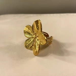 Blomma ring - Säljer denna blomringen i guld. Går att justera. Endast använd 1 gång så i nyskick. Tryck gärna på ”köp nu”.