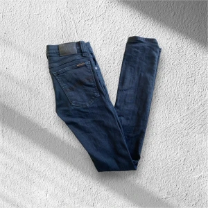 Nudie Jeans - Säljer ett par snygga mörkblå jeans från Nudie Jeans. De har en klassisk femficksdesign och är tillverkade i högkvalitativt denim. skick 8,5/10 Pris 349