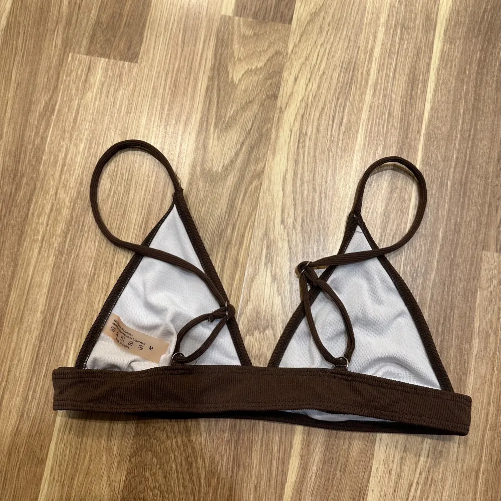 En snygg brun ribbad bikiniöverdel i trekantsmodell. Den har smala axelband och en enkel design som passar perfekt för sommaren. Materialet känns mjukt och bekvämt mot huden. Inte använd! Storlek M. Övrigt.