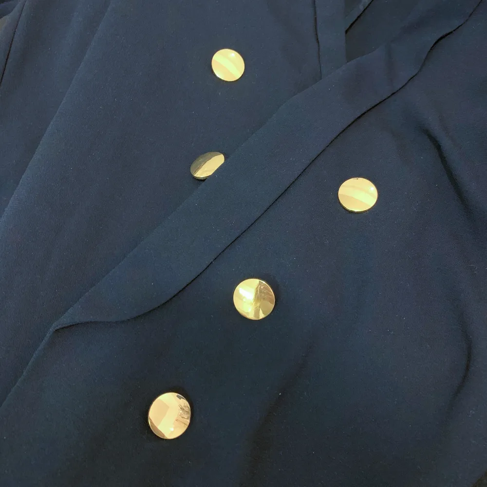 Mörk marinblå kavaj från Gina Tricot i storlek 36. Har 3 guldiga knappar på vardera sida. Inga fickor och ingen knäppning. . Kostymer.