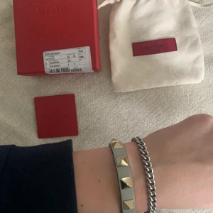 Valentino amrband  - Intressekoll på mitt unika valentino armband. Det är ett blått/grått armband som är slutsåld på hemsidan och i toppskick. Fick det i julklapp och använd fåtal gånger. Skriv till mig om du har några mer funderingar. Kartong och dustbag samt även tag medföljer💓 nypris cirka 1700kr