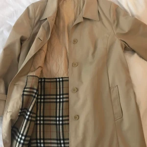Vintage trenchcoat  - En supersnygg trenchcoat med burberry liknande mönster inuti, i superfint skick och i väldigt bra kvalite. Köpt på vintageaffär förra året och kommer aldrig till användning💕  står ingen storlek men skulle säga ca en L✨ Köparen står för frakt