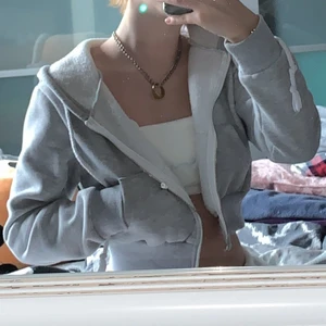 Grå, croppad sip-up hoodie - En skön, grå, croppad sip-up hoodie med riktiga och hyfsat djupa fickor. Insidan är lite fluffig. Långa snören. Bra kvalitet, håller värmen okej! Inga skador.