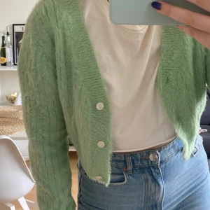 Stickad grön kofta - Jättefin mintgrön kofta i lurvigt material, man kan även ha den stängd som en vanlig tröja. Croppad modell, bra kvalite!  Storlek M men passar också S. betalning via swish och köpare står för frakten💚💞💛🌈💜💘