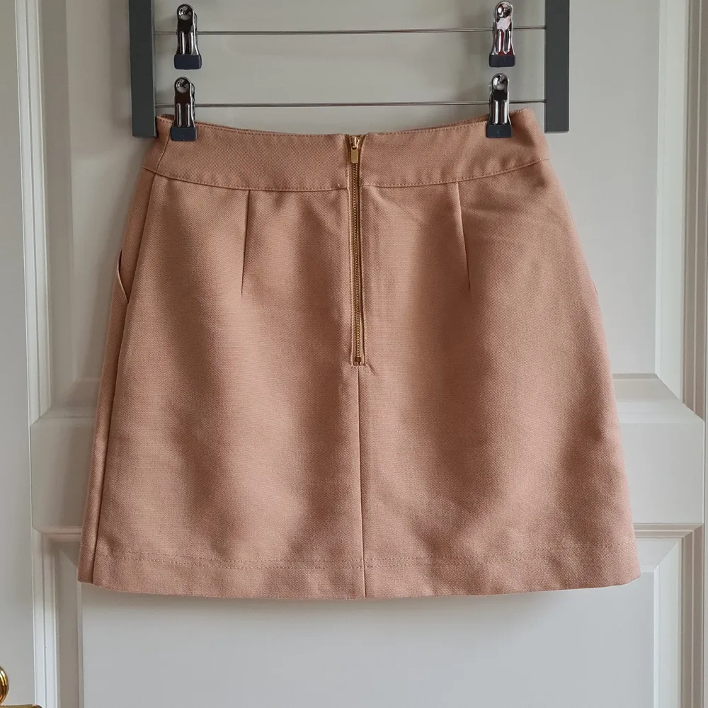 Beige mini skirt from H&M with pockets. It is made from 100% cotton so it is great for spring/summer season ☀️ Zipper and button fastening in the back. Size S, waist 36 cm, total length 41 cm.. Kjolar.