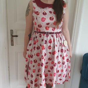 Helt ny Rockabilly Klänning Storlek 14 - Vit Rockabillyklänning i nyskick med lila granatäpplemönster, krage och bälte