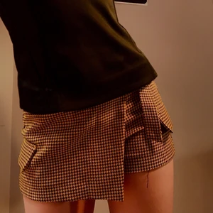 Rutig Shortskjol  - Knappt använd Cluelessliknande shortskjol från Bershka. Säljer p.g.a. växte ur den. Frakten ingår ej. (Tråd på första bilden är från tröjan)