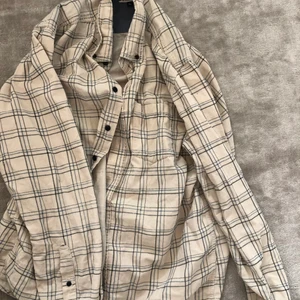 Oversize Beige Manchester tyg skjorta - Jättefin beige oversize skjorta i manchestertyg och blåa rutiga detaljer. Knappt använd i nyskick helt utan skador eller fläckar. Vid frågor är det bara att skriva ! 💞