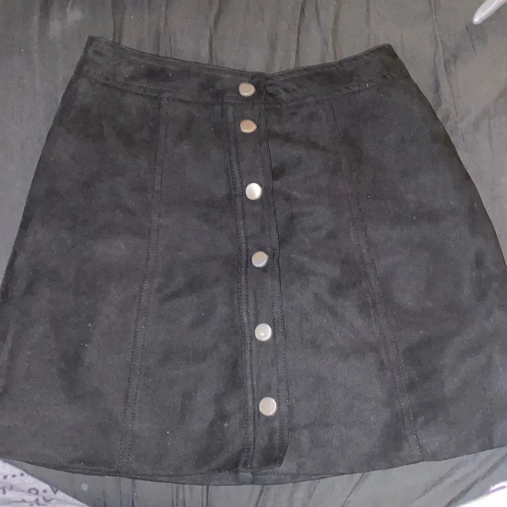 En svart h&m kjol i Sämskskinn med metall knappar, den sitter jätte fint på. Ny och aldrig använd då det inte är min stil längre men annars jätte gullig😊🖤!!. Kjolar.