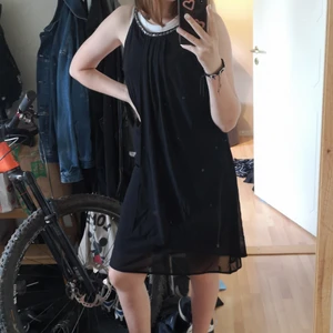 Afton klänning  - En svart enkel afton klänning med lite silver detaljer i urringningen. Använd 1 gång på en begravning och sedan hängt i garderoben sedan 3 år tillbaka. 