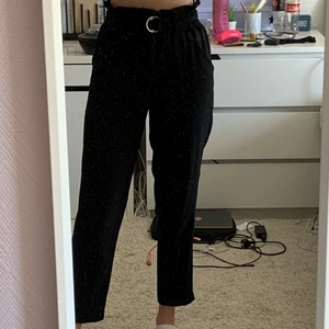 Svarta kostymbyxor  - Svarta kostymbyxor från NA-KD med avtagbart skärp. Säljer då dom är lite korta på mig. Innerbenslängden på byxorna är 68cm.