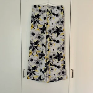 Blommiga byxor - Gula byxor med svarta, gråa och vita blommor från Monki. Har blivit för små för mig och säljer därför dessa vidare. Byxorna är lite kortare i modellen och slutar vid mitten av vaden. Använda några få gånger och är i mycket gott skick! 