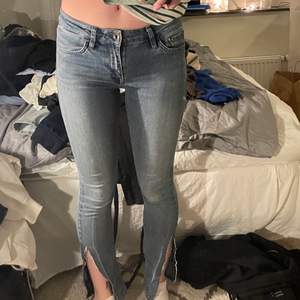 Säljer dessa lågmidjade jeans med slit, storlek 34/36