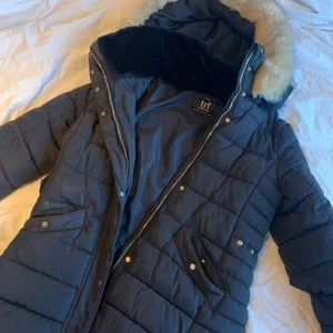 Lång svart vinterjacka från Zara🖤 - En svart lång vinterjacka som går ner till låren! Den har en avtagbar luva, och luvan har en avtagbar päls, som är fake! ❤️ Den har både dragkedja, knappar och bälte! Även två rymliga fickor. Originalpris 800kr säljs för 200kr. Den är i väldigt bra skick och varm ❄️